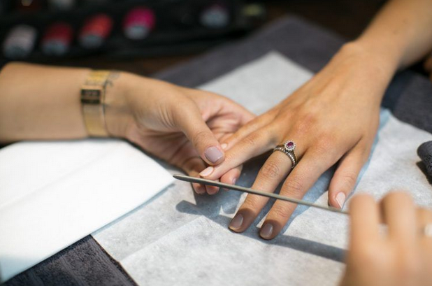 Nail technician filing finger hands