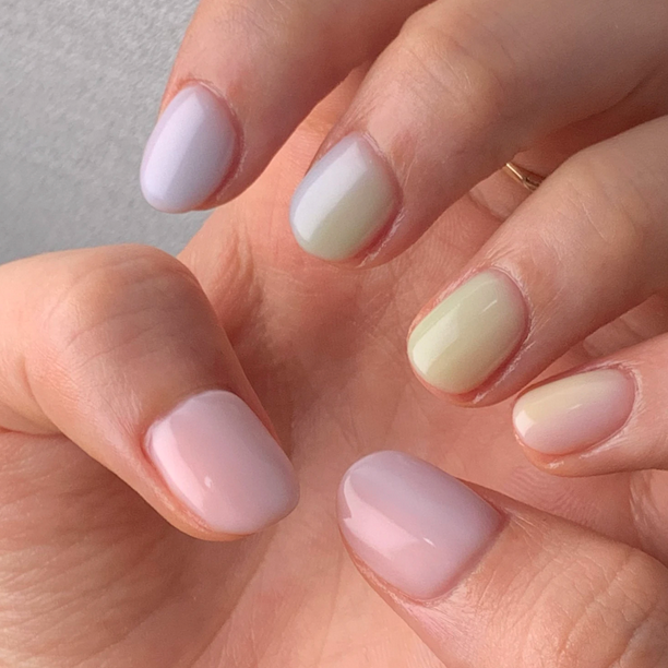Finger nails painted in pink blue green colors