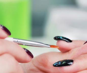 Manicurist applying blue polish