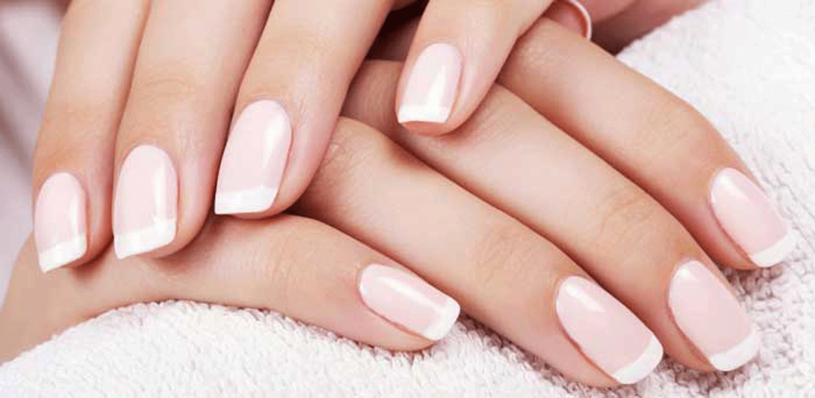 A beautiful finger nails painted in pink with white tips on a white towel