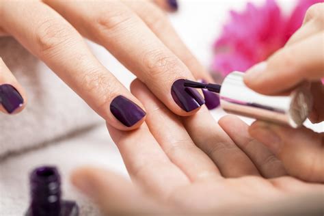 Applying purple brown finger nails polish