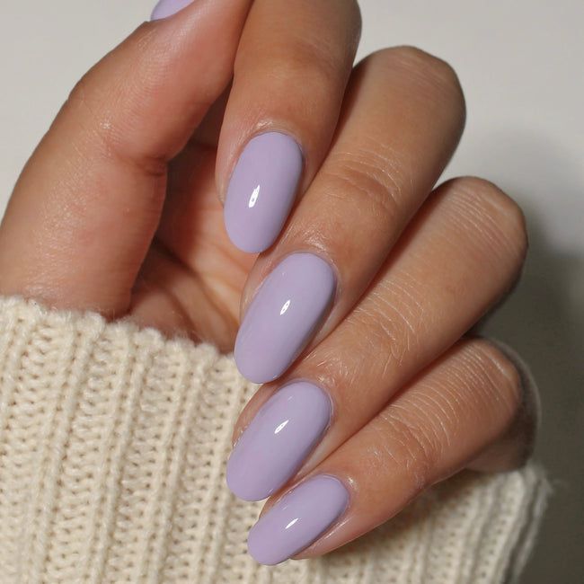 Finger nails painted in dark violet polish
