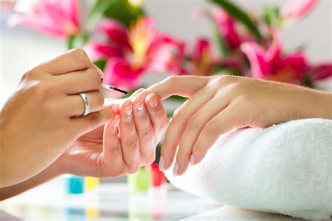 Nail technician applying a clear finger nail polish