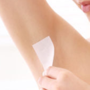 Woman waxing her underarm with tape